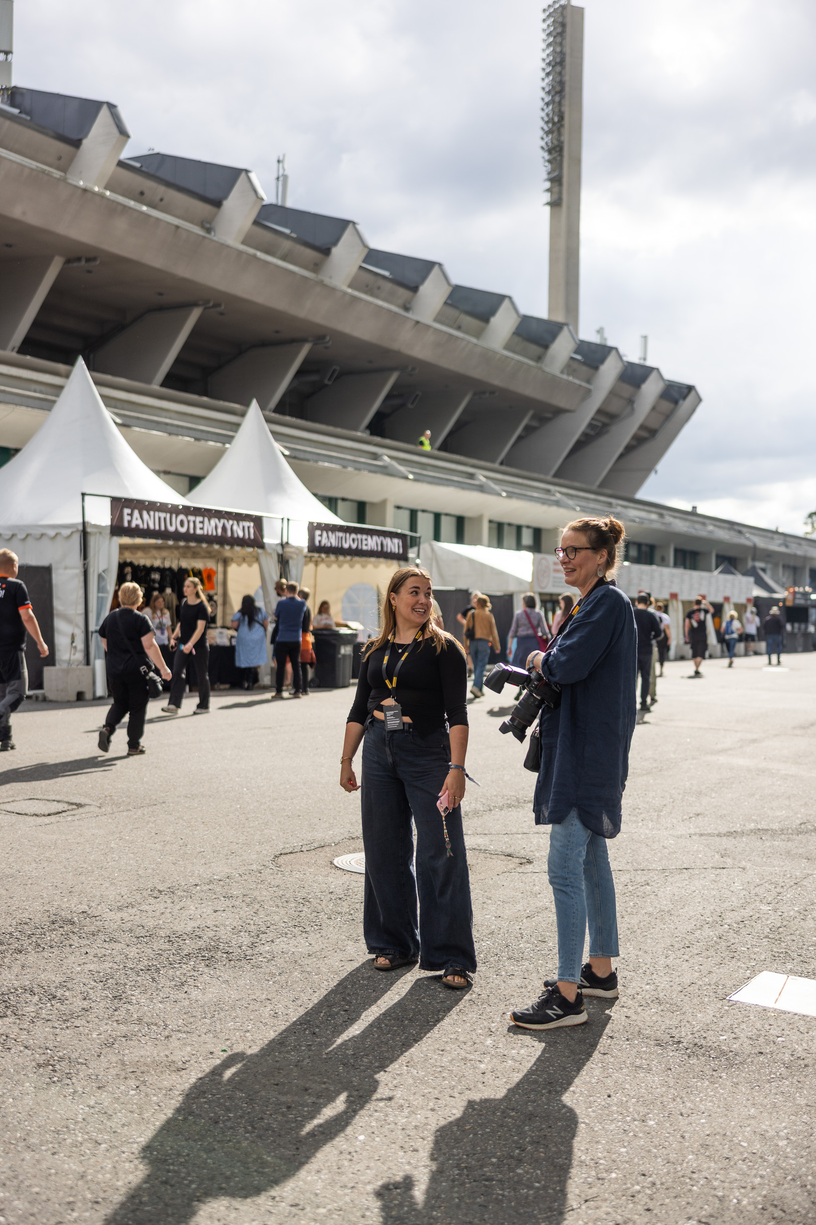 Toimittaja ja kuvaaja stadionin edustalla