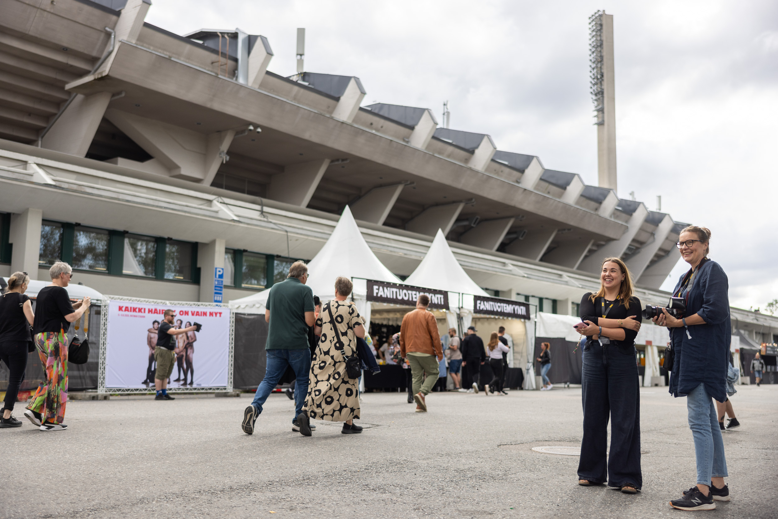 Toimittaja ja kuvaaja stadionin edustalla